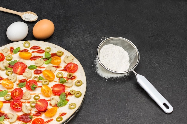 Round dough base for pizza Food ingredients for cooking pizza Flour in sieve Sprig of wheat