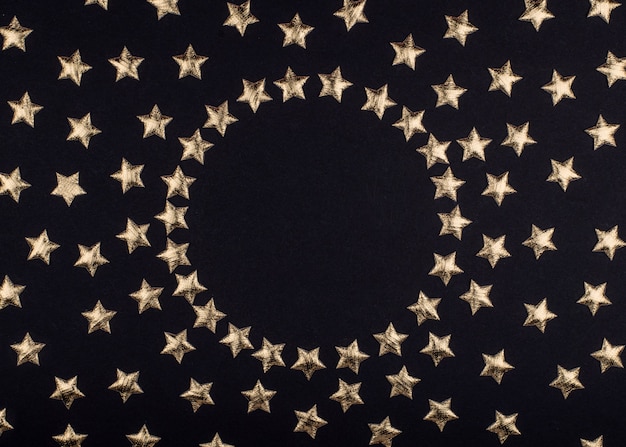 Foto cornice rotonda di sfondo nero vacanza festiva con stelle lucenti. vista piana laico e dall'alto