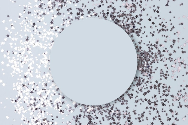 Round frame made of silver colored stars confetti