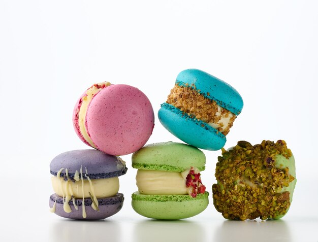 Round french cakes made from almond flour macarons on a white background. Raspberry, pistachio and lavender flavor