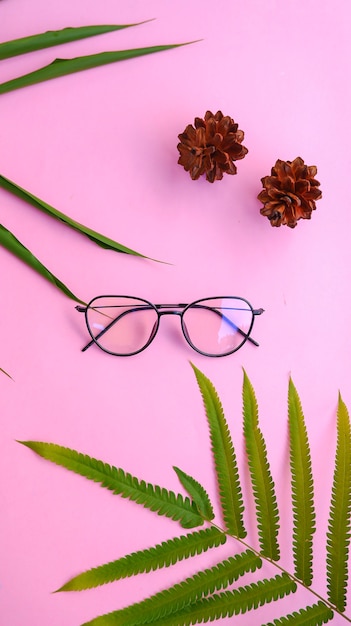 Круглые очки на фото в минималистичном летнем стиле на пастельно-розовом цветном фоне.