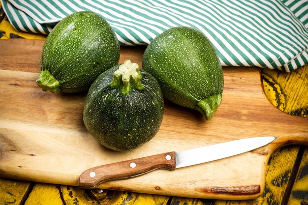 Round green zucchini on a wooden table