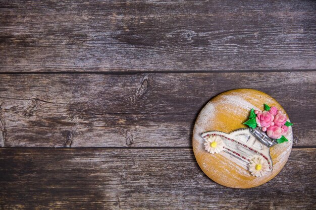 Photo round handpainted gingerbread on wooden background beautiful car with flowers flat lay copy space sweet dessert as a gift for women's day on 8 march