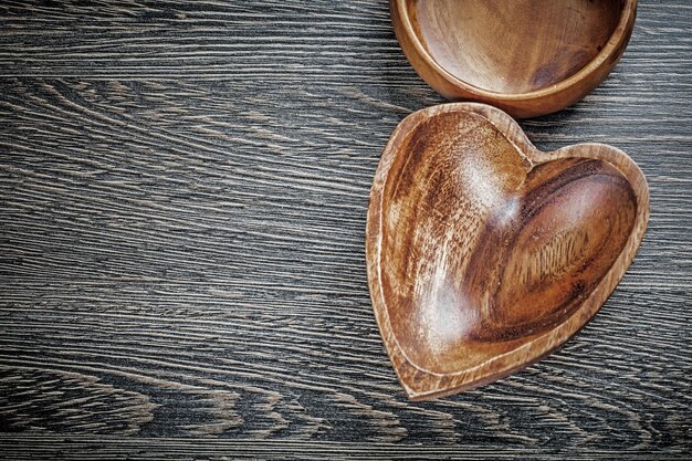 Round heartshaped wooden bowls on wood board