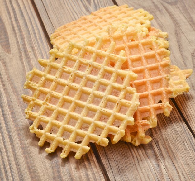 Round home-made waffles close-up on a wooden table.