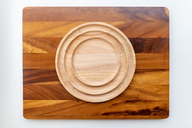 The round lacquered rubber wood plate is stacked on several layers on a wooden plate made of a Jamjuree tree with a copy space.