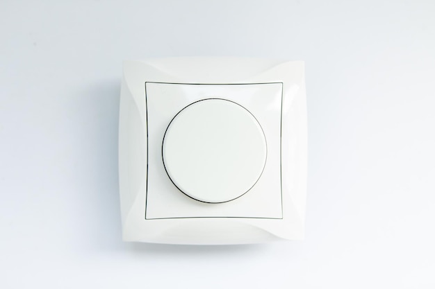 Round light switch on a white background