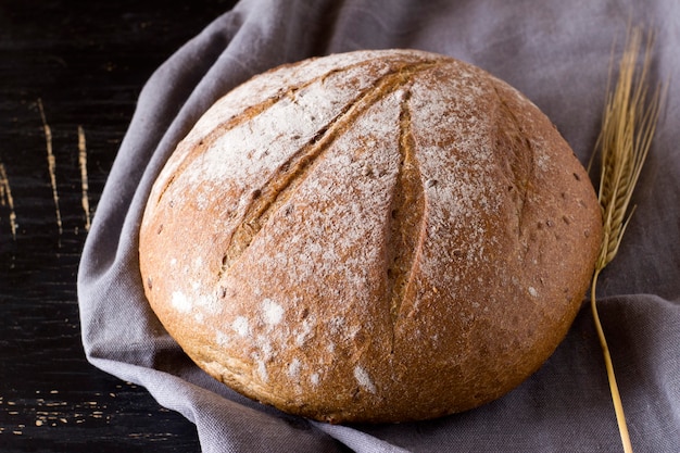 Round loaf of buckwheat bread on dark background