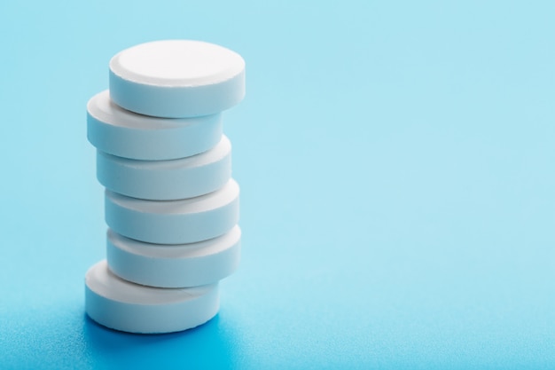 Round medicinal pills tower on blue