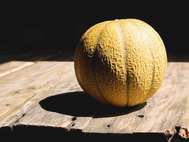 Round melon isolated on a wooden table