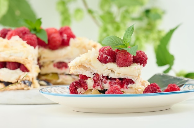 Torta di meringa rotonda con lamponi freschi su sfondo bianco dessert pavlova