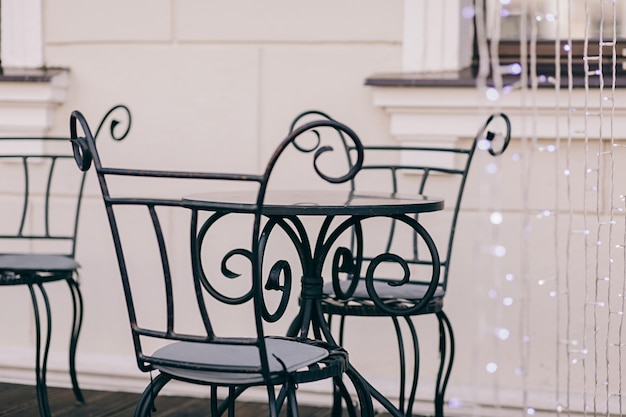 Round metal table and vintage chairs in a street cafe