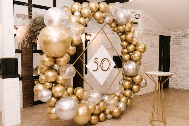 Круглая фотозона украшена золотыми и серебряными шарами к 50-летию, работа авиадизайнера