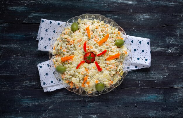 Photo round plate of russian salad with mayonnaise and vegetables