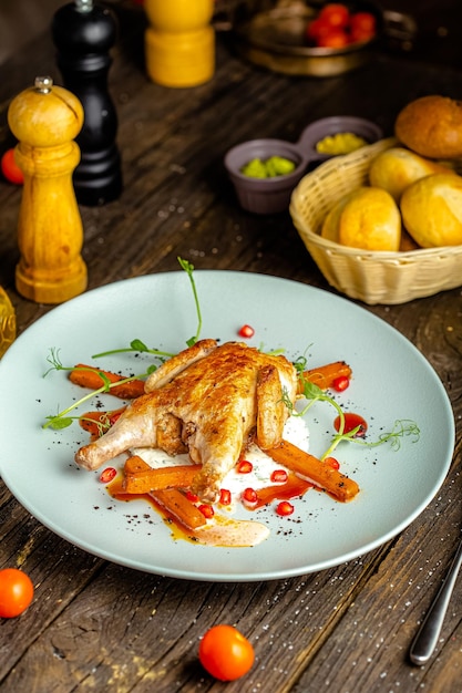 on a round plate, whole grilled chicken, vegetables, fork, knife, bread, greens