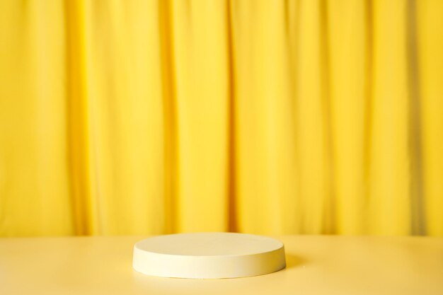 Round podium pedestal on a bright yellow curtain background