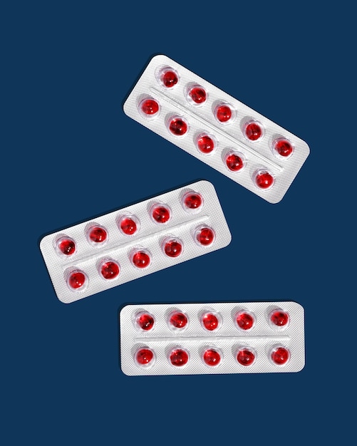 Round red translucent pills in blister packs on a blue background