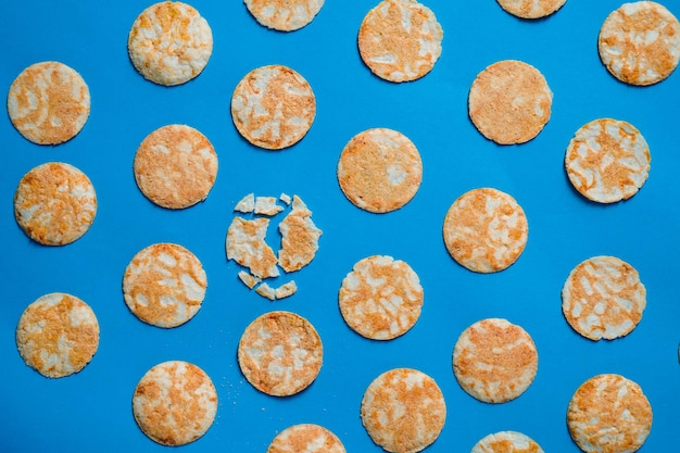 Round rice chips on a blue paper background