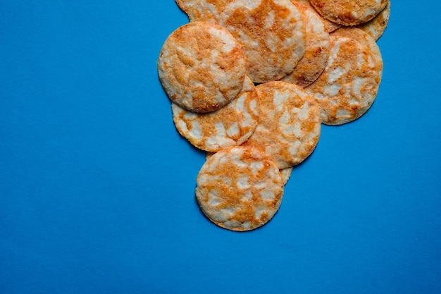 Round rice chips on a blue paper background