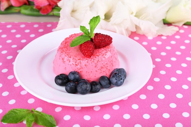 물방울 무늬 테이블 천에 접시에 딸기와 둥근 모양의 케이크