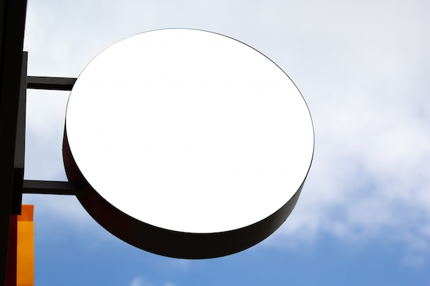 Round shop signboard mockup against blue sky