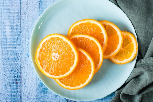 식탁 위의 접시에 있는 신선한 오렌지의 둥근 조각 비타민 항산화 다이어트 상위 뷰 확대