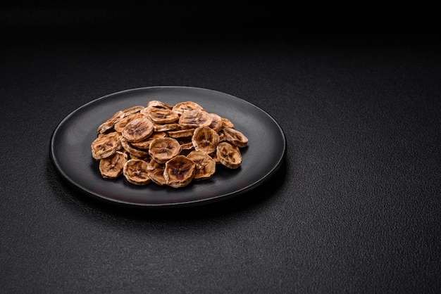 Round slices of sweet banana on a dark concrete background Ingredients for making vegan sweets