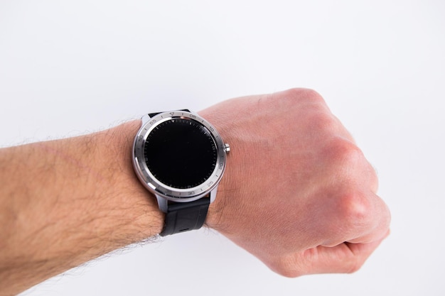 A round smart watch on a male hand on a white background