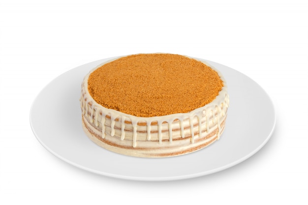 A round sponge cake with cream lies on white plate on white