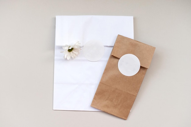 Round sticker mockup on gift white and kraft package packaging with empty sticker adhesive label