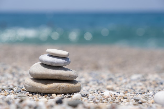 Round stones lie on top of each other in a column on the seashore