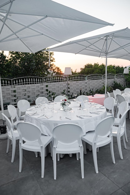 Round table in a restaurant on a summer terrace under the open sky at sunrise