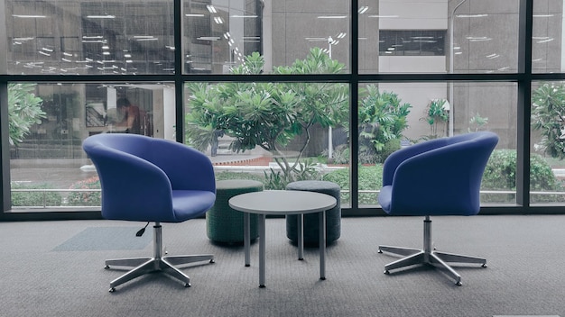 a round table with chairs and a table in front of a large window