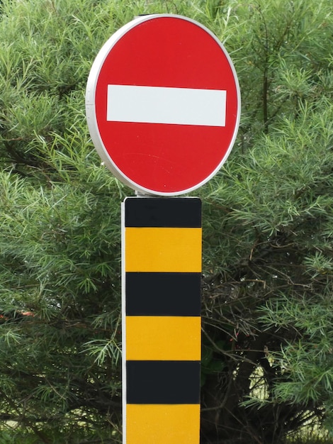 Round traffic sign for no entry with yellow black pole