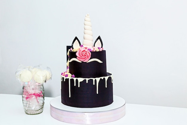 Round two-tiered cake in the form of a unicorn on a white background