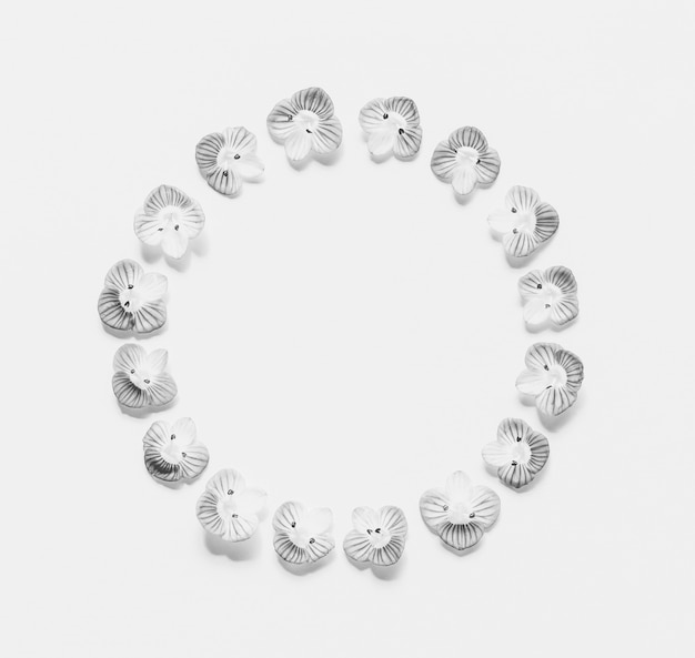 Round vintage frame of small flowers on a white  with space for text, black and white  . Flat lay, top view