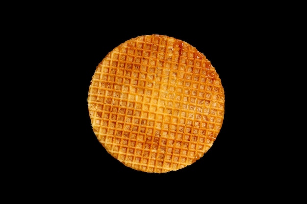 Round waffle isolated on a black background. High quality photo