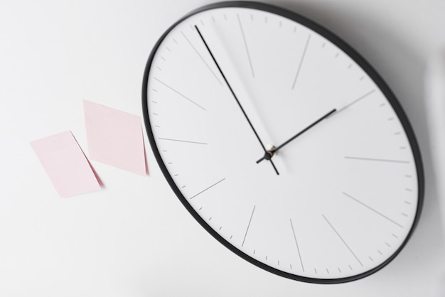 Round wall clock and pink stickers on white