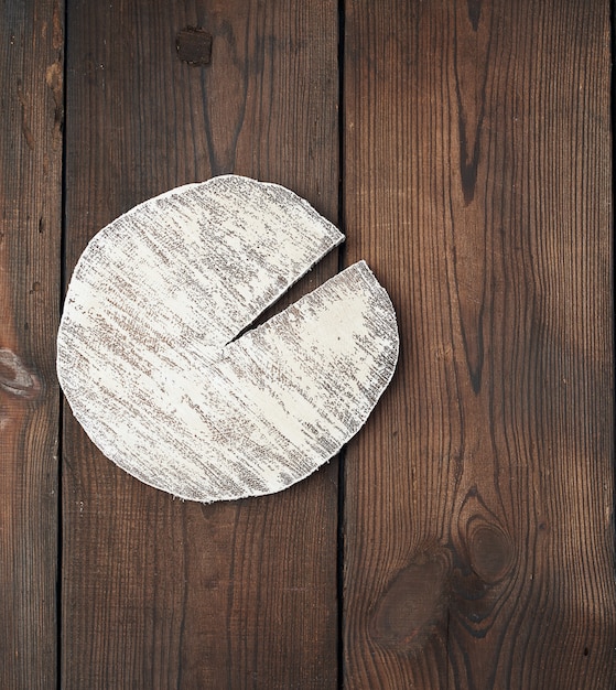 Round white cutting board on a brown wooden surface