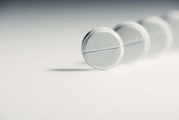 Round white medical tablets on grey background, medicine and healthcare concept