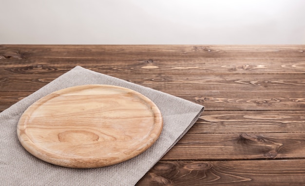 Round wooden board with tablecloth.