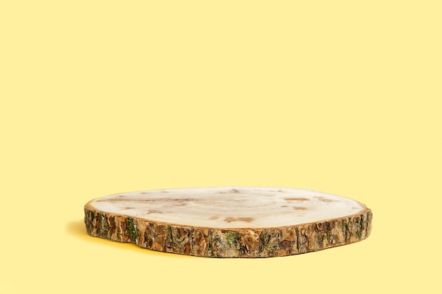 A round wooden coaster with a yellow background that says'tree'on it