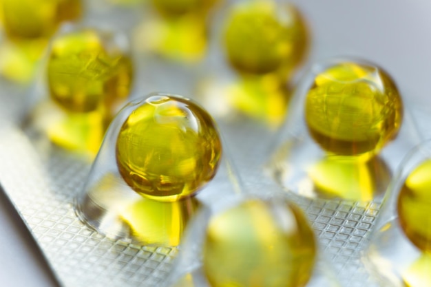 Round yellow capsules of vitamins in a blister pack closeup\
tablet in the package closeup