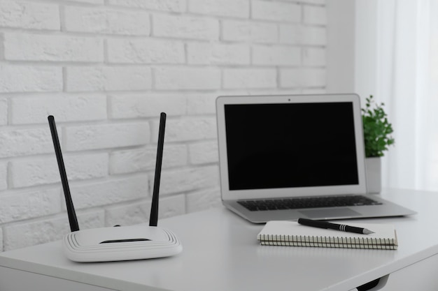 Router modern laptop and notebook on white table indoors