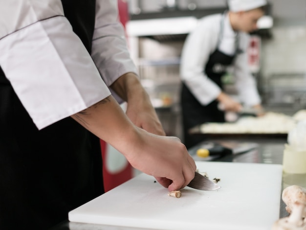 おいしいレストランの食事の材料を準備する日常の仕事。キッチンで仕事中の料理人