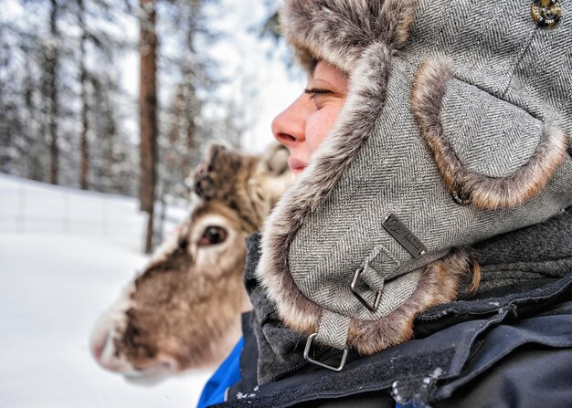 Фото Рованиеми, финляндия - 3 марта 2017 г.: девушка и северный олень во время сафари зимой рованиеми, лапландия, финляндия