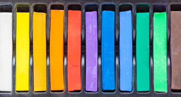 Row of artistic watercolor or pastel crayons in box