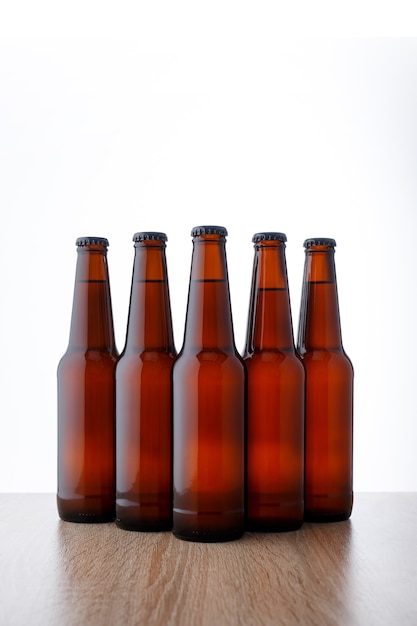白い背景の上のビール瓶の列。 5つのオブジェクト