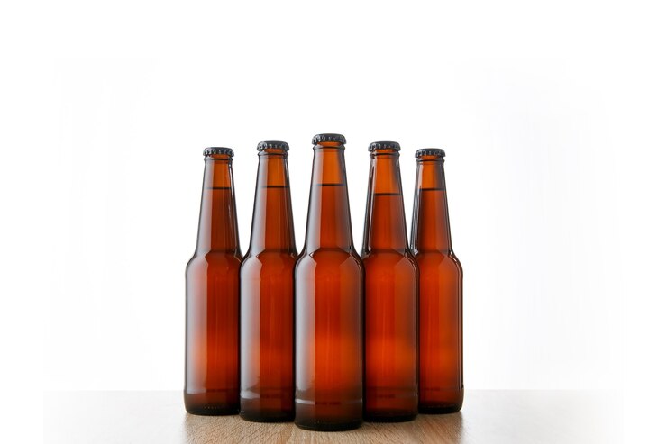 Photo 白い背景の上のビール瓶の列。 5つのオブジェクト