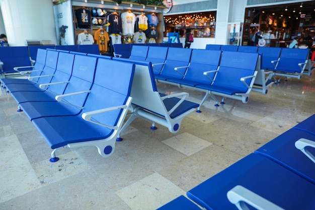 A row of blue chairs in an airport terminal